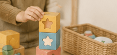 A child stacking colourful shape blocks beside a woven basket